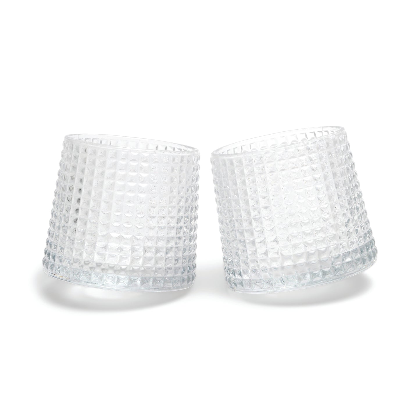 Two of The Lola fluted glasses, featuring a unique spherical bottom design, are displayed tilted towards each other on a white background.