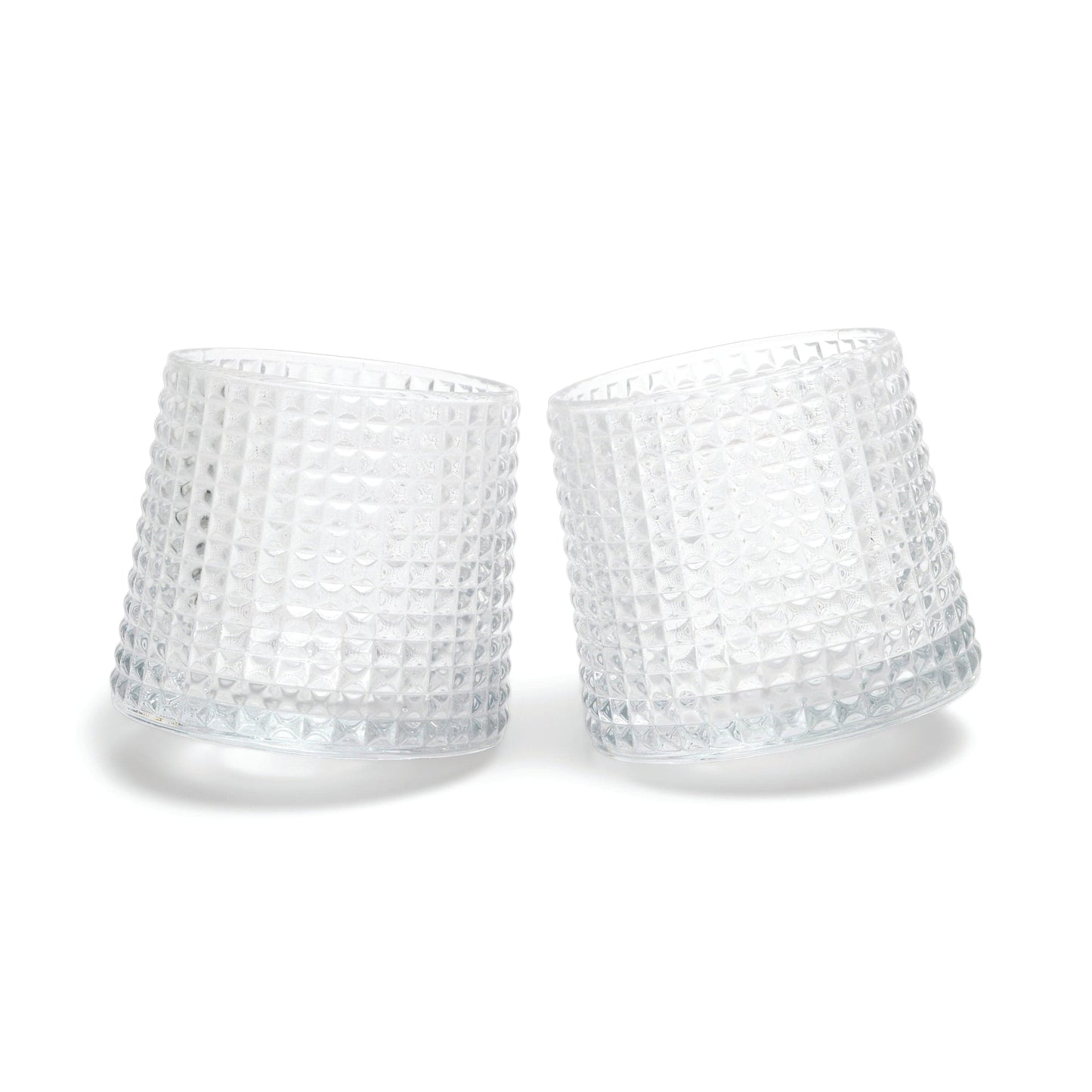 Two of The Lola fluted glasses, featuring a unique spherical bottom design, are displayed tilted towards each other on a white background.