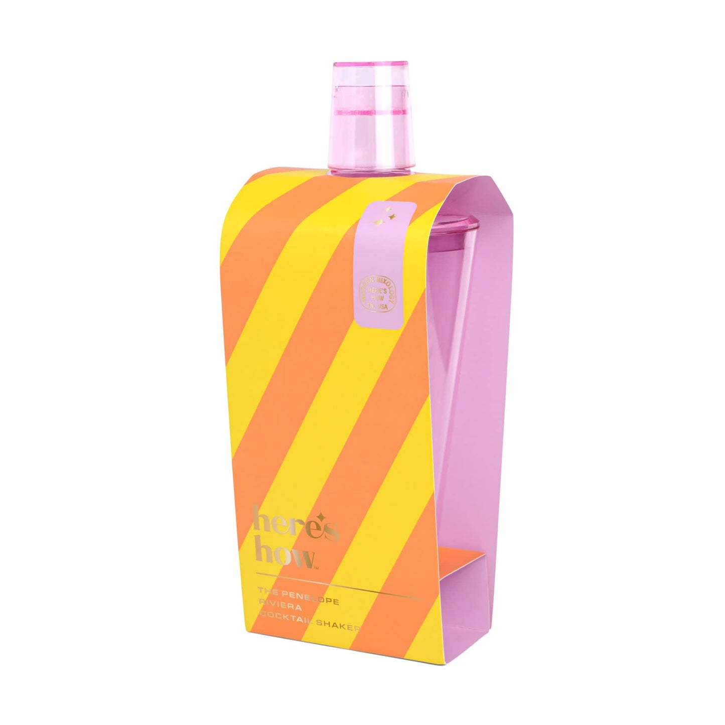 The Penelope Cocktail Shaker is a clear outdoor shaker with a pink lid, packaged in a yellow and orange striped sleeve that says here’s how—ideal for mixology enthusiasts and al fresco entertaining.