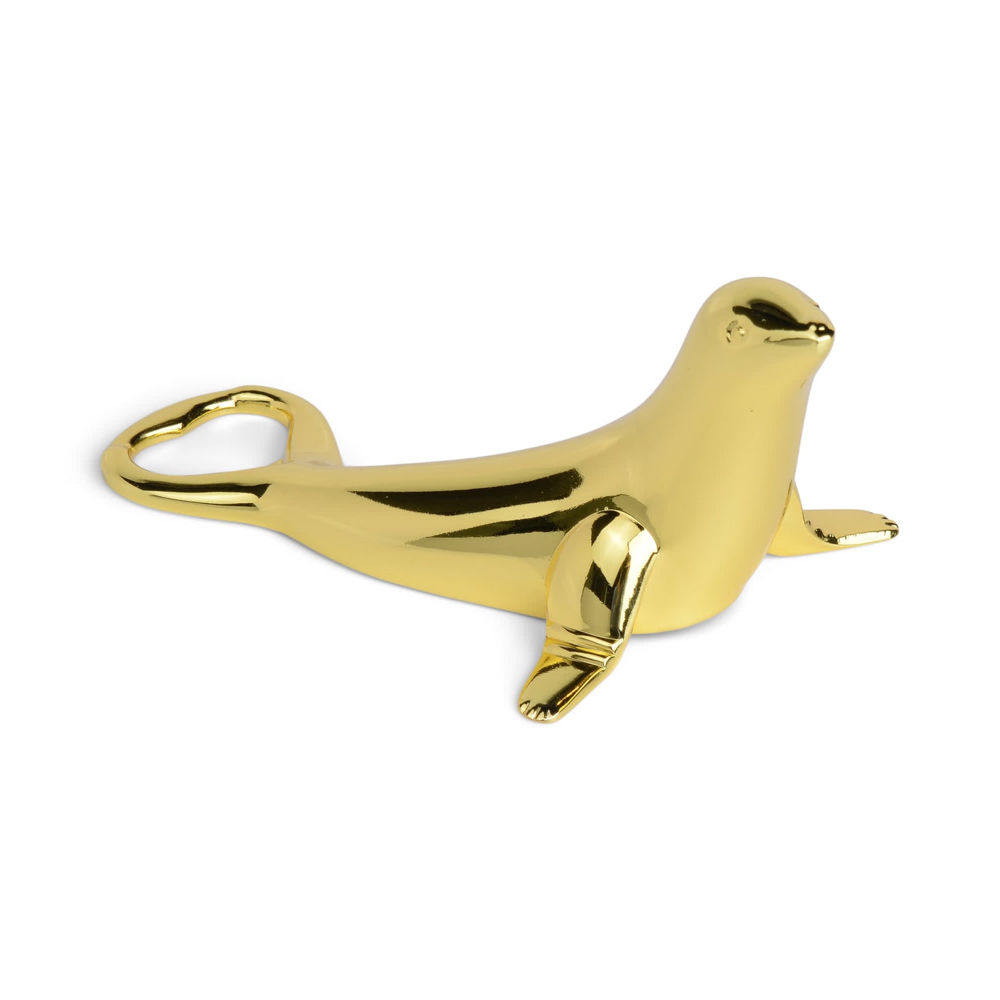 The Blu Seal Bottle Opener, a gold-colored seal-shaped tool with a heart-shaped tail opening, adds oceanside elegance to your entertaining on a white background.