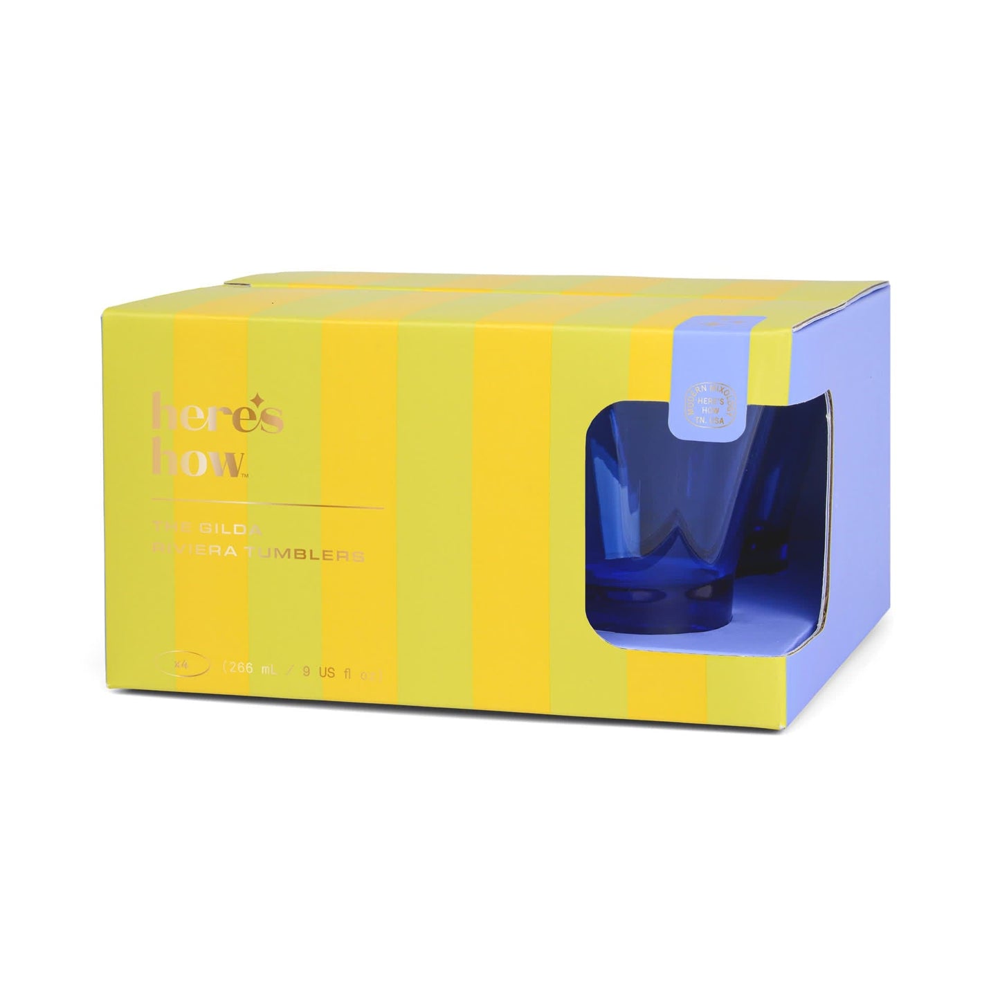 A yellow and light blue box labeled heres how. displays two The Gilda Tumbler glasses, ideal for cocktails, partially visible through a cut-out window on the right side of the packaging.