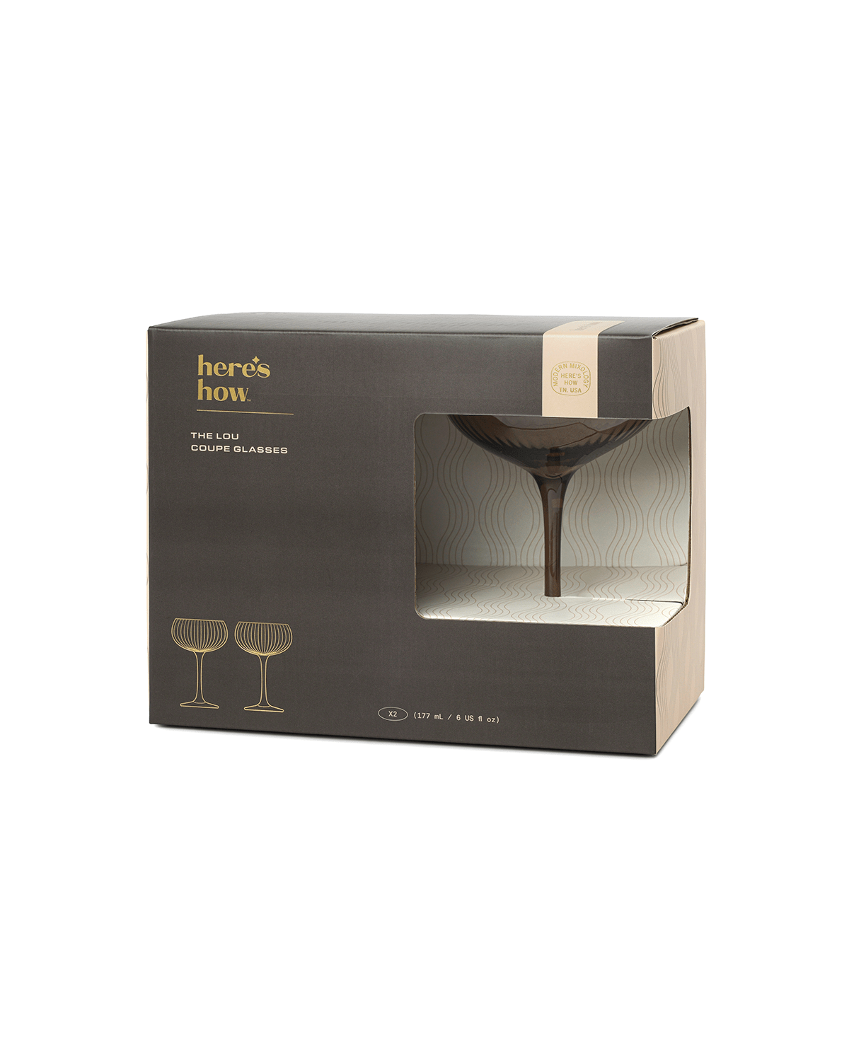 A box of two The Lou soda lime glass coupe glasses, in black and beige packaging with gold text, glass illustrations, and a partial window displaying one glass inside.