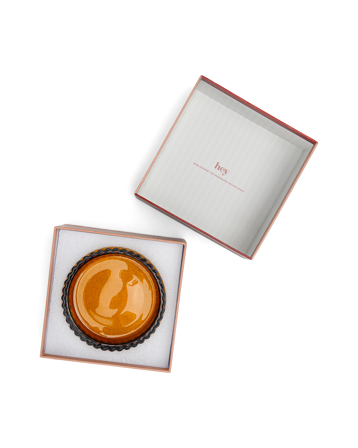 The Mookie + Lenny ceramic dish in brown comes in a square gift box with a white foam insert; the open lid, printed with hey inside, sits beside it—ideal for pairing with your colored glass home bar essentials.