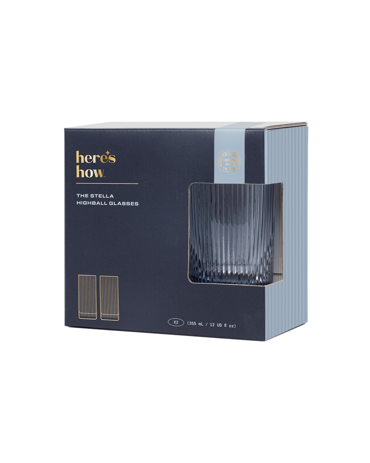 A dark blue heres how box holds The Stella, a set of fluted glasses. One soda lime glass is partially visible through the window on the front.