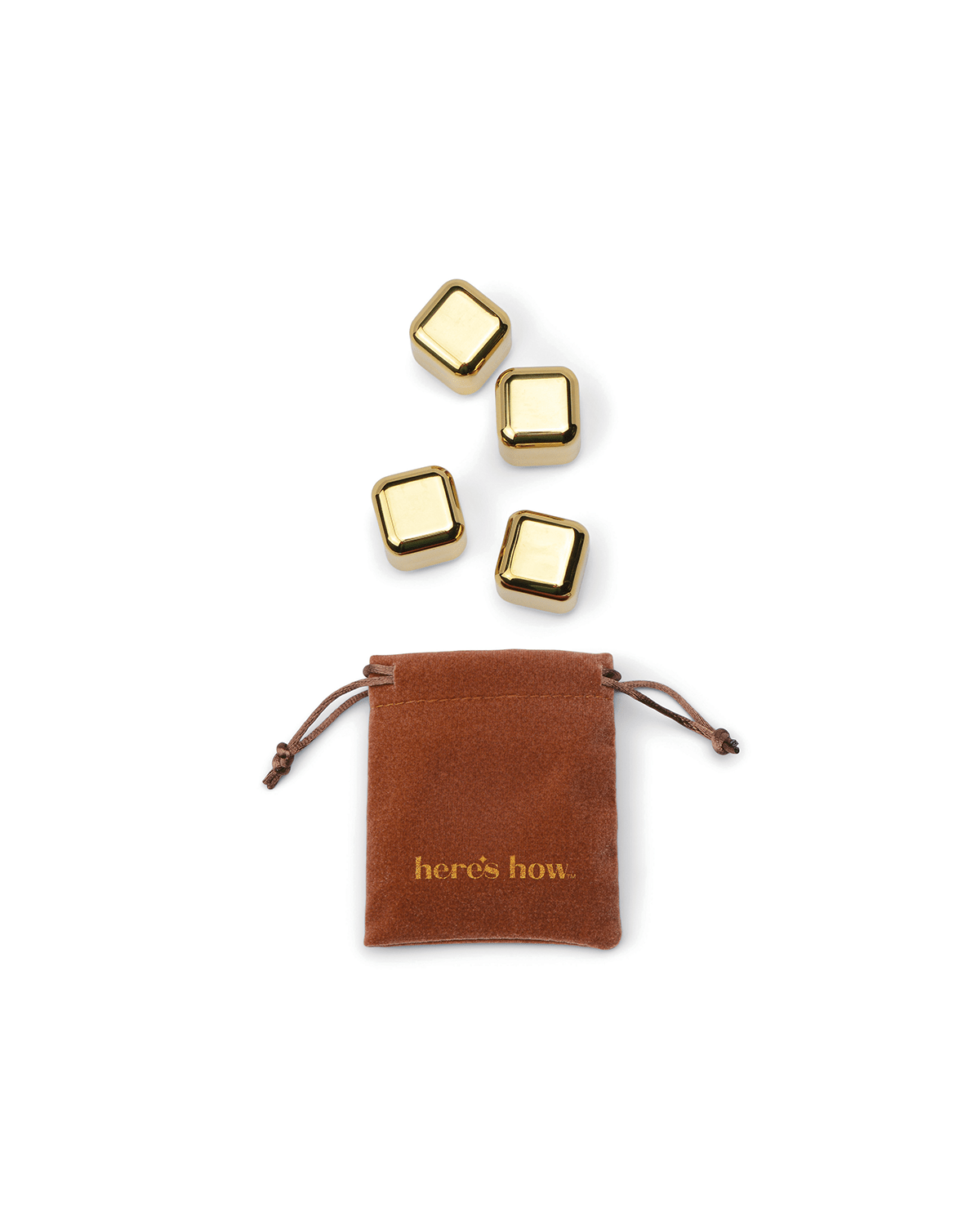 Four Ruby Cubes gold-colored stainless-steel cocktail chillers are arranged above a brown drawstring pouch labeled heres how. on a white background. These freezable cubes keep drinks cold without dilution.