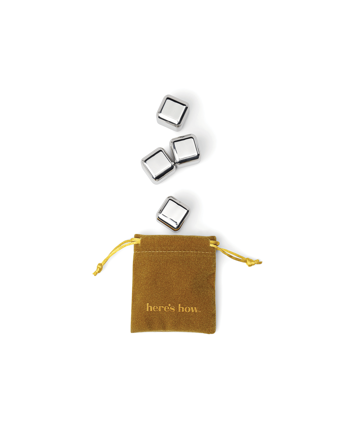 Four Ruby Cubes stainless-steel cocktail chillers rest above a small brown drawstring pouch labeled heres how on a white background. These freezable cubes keep your drinks cold without diluting them.