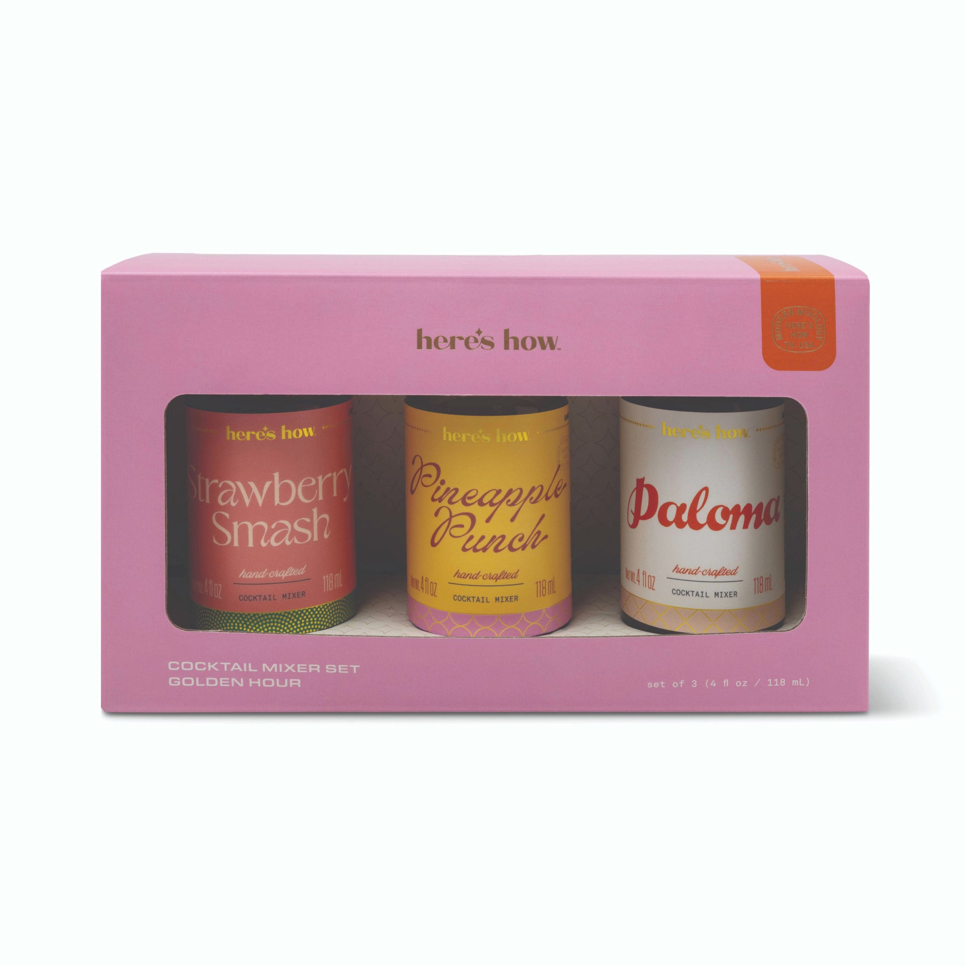 A pink boxed cocktail mixer set from Here's How, containing three 12 oz cans: Strawberry Smash, Pineapple Punch, and Paloma, shown on a clean white background.