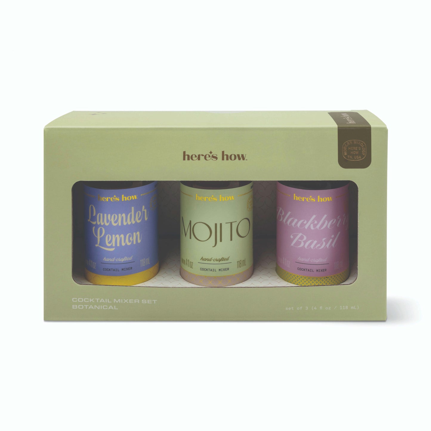 A boxed cocktail mixer set by here's how, containing three botanical tins: Lavender Lemon, Mojito, and Blackberry Basil, presented in a sage green box with a clear front window.