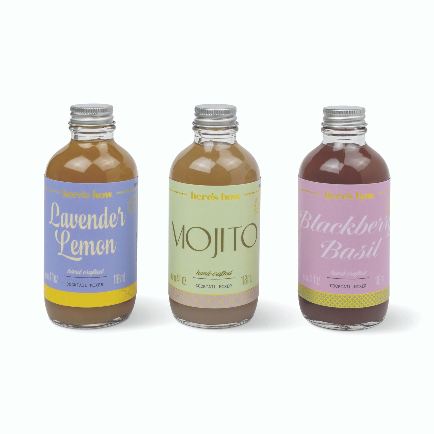Three small glass bottles of cocktail mix with silver caps, labeled Lavender Lemon, Mojito, and Blackberry Basil, arranged on a white background.