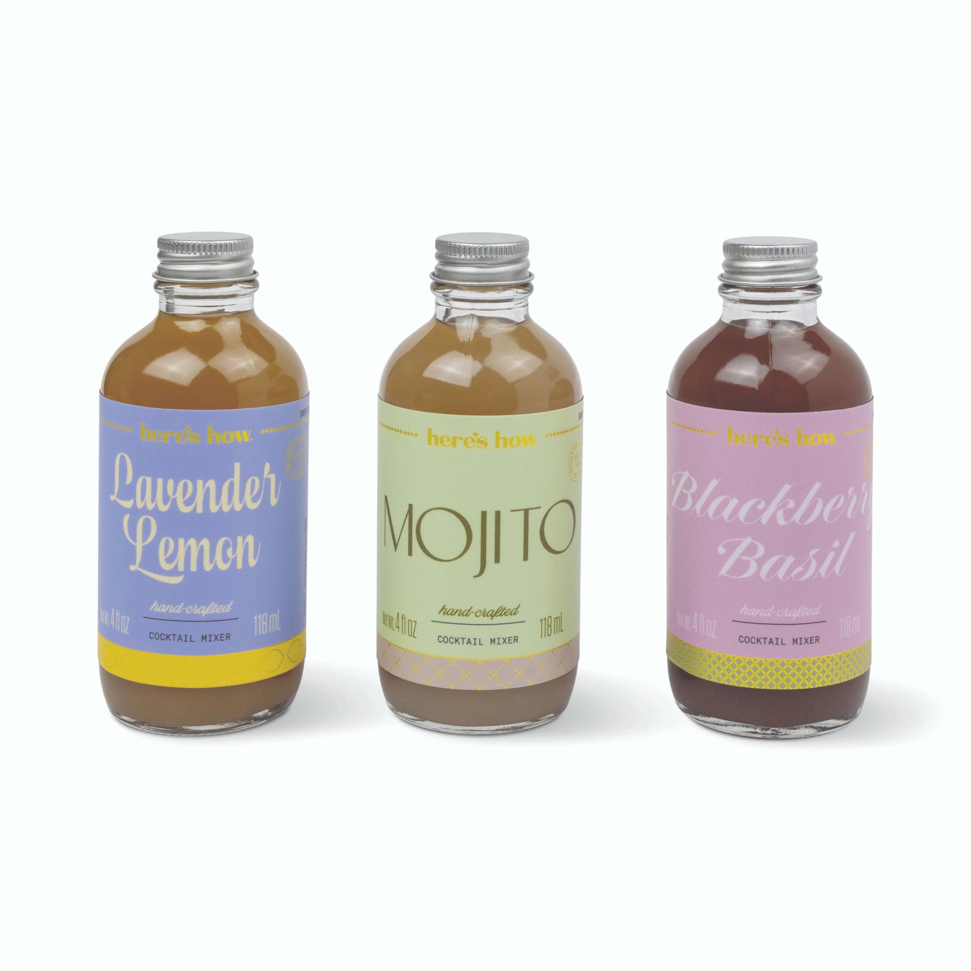 Three small glass bottles of cocktail mix with silver caps, labeled Lavender Lemon, Mojito, and Blackberry Basil, arranged on a white background.