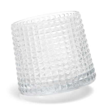 The Lola textured clear glass tumbler with a spherical bottom design lies on its side against a white background.