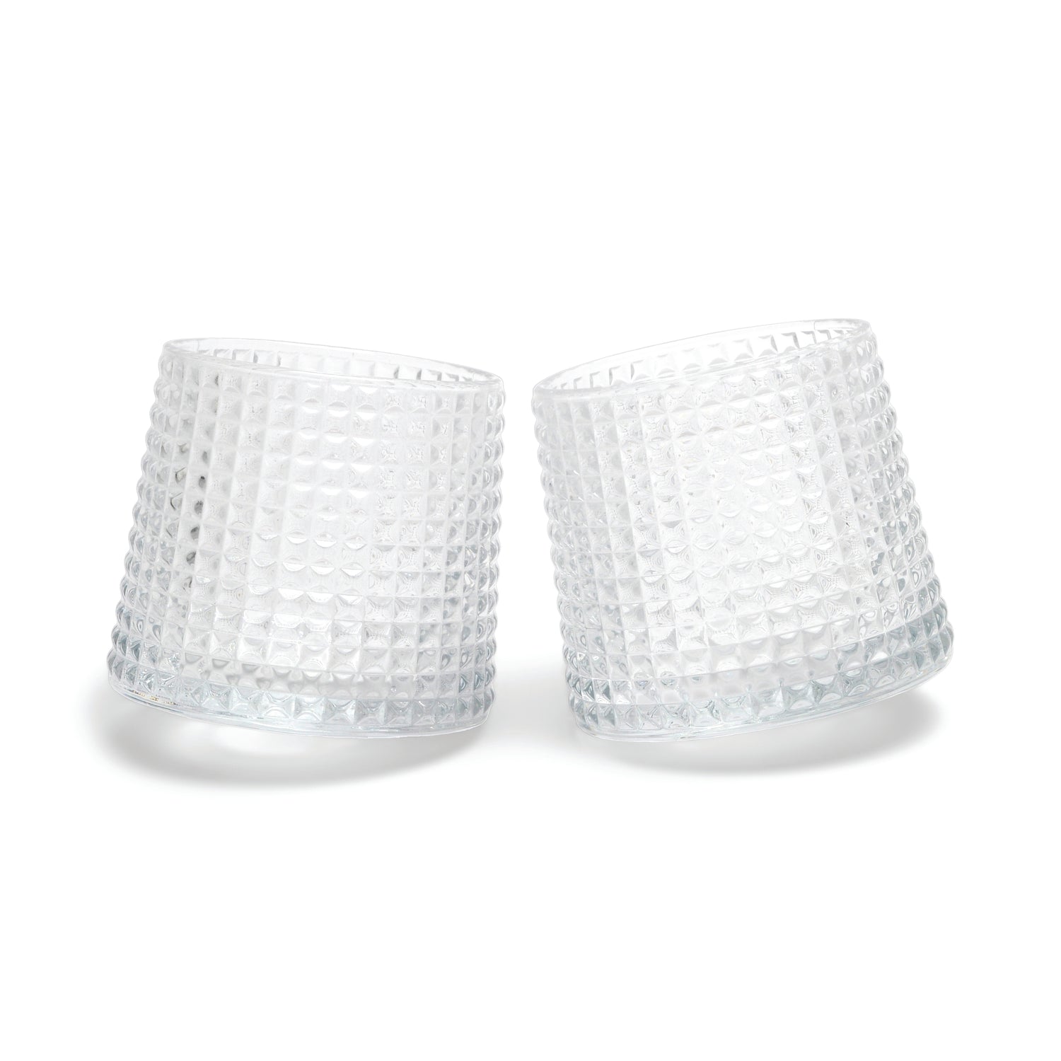Two of The Lola fluted glasses, featuring a unique spherical bottom design, are displayed tilted towards each other on a white background.