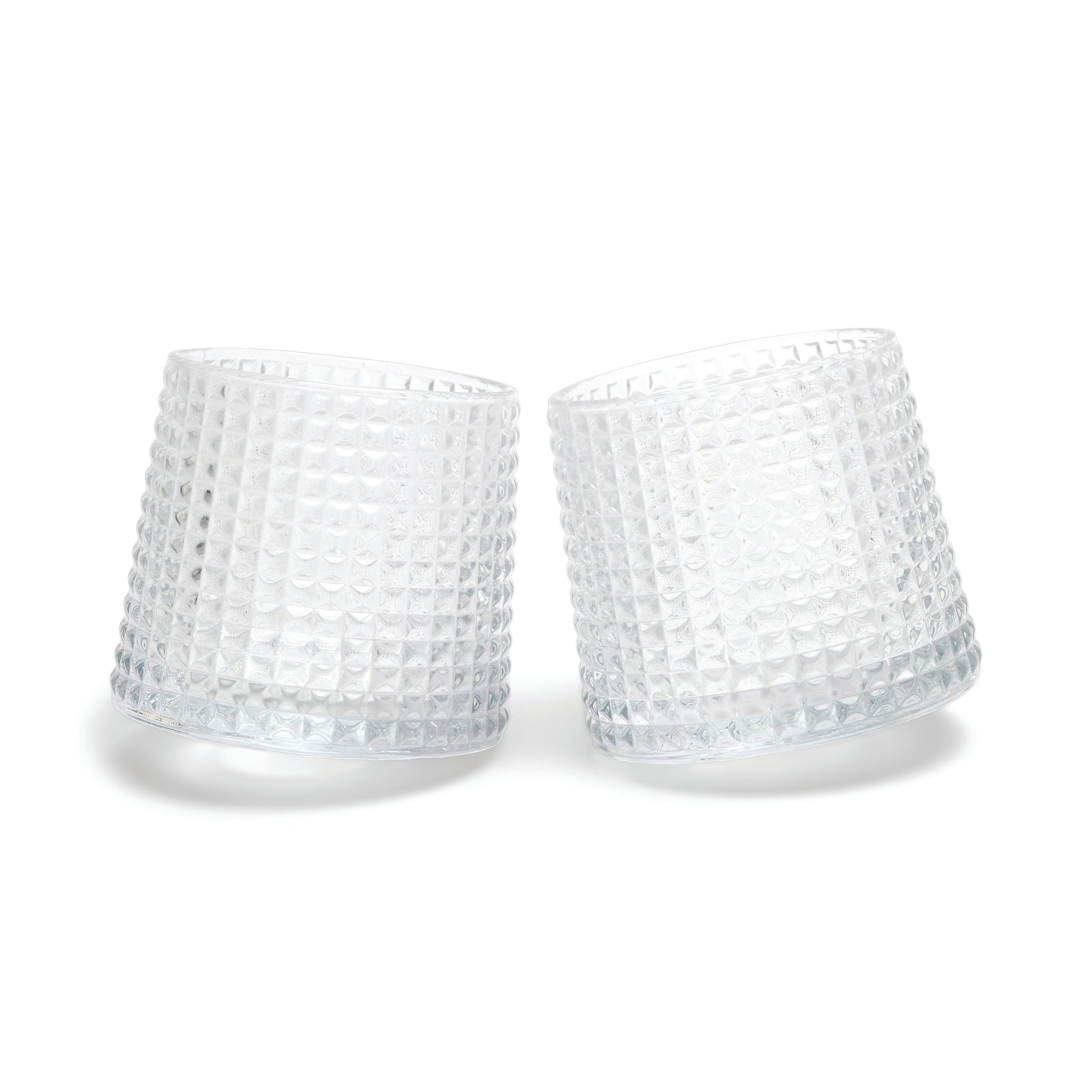 Two of The Lola fluted glasses, featuring a unique spherical bottom design, are displayed tilted towards each other on a white background.
