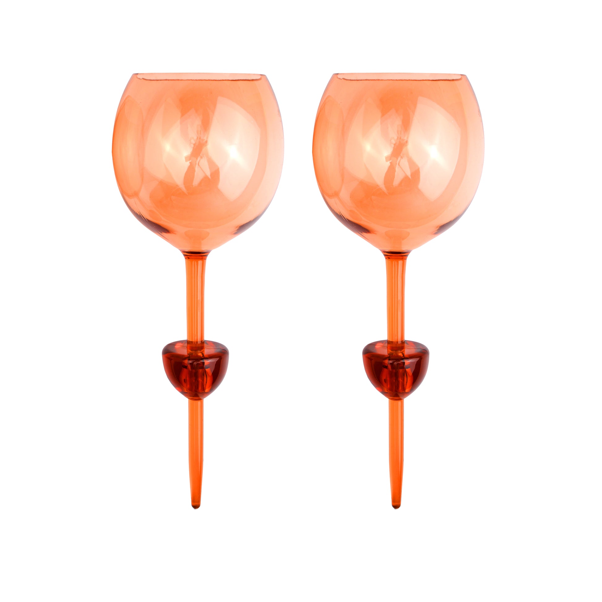 Two Bodie Riviera Glasses with orange-tinted, round bowls and thick stems stand side by side on a white background—ideal for outdoor enjoyment or stylish picnics.