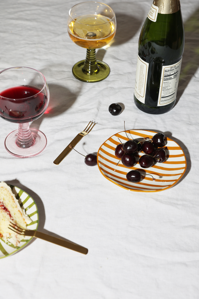 Table set up with glassware and plate of cherries. 