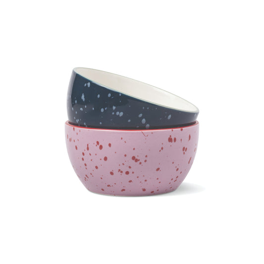 The Bella Ceramic Dipping Bowls - Navy + Lilac Splatter featuring two stacked bowls: a navy top bowl with white speckles and a lilac bottom bowl with red speckles.
